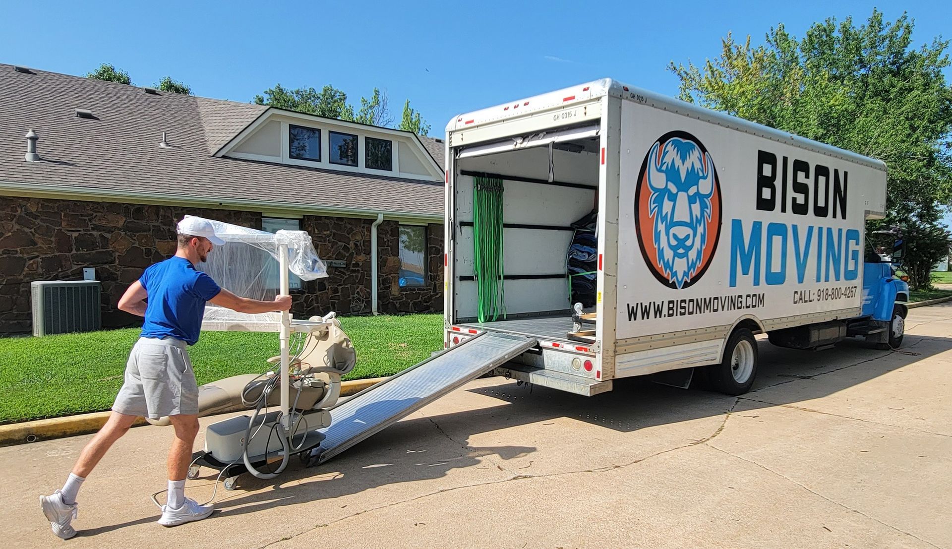 A man is pushing a chair into a bison moving truck - Tulsa, OK - Bison Moving
