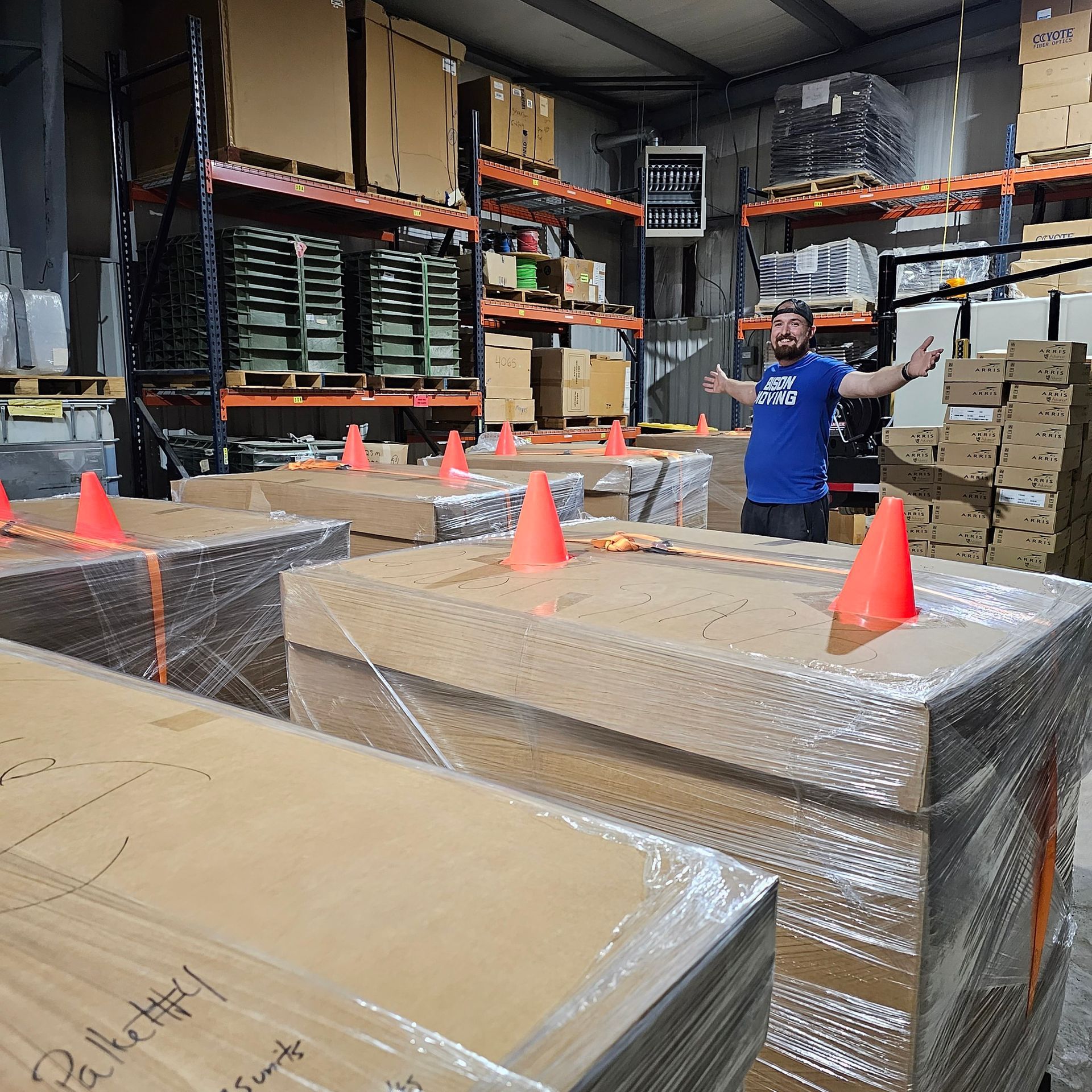 A man in a blue shirt is standing in a warehouse - Tulsa, OK - Bison Moving