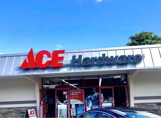 A car is parked in front of an ace hardware store