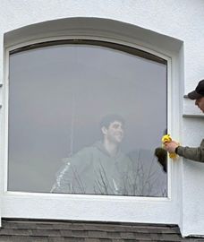 Window repair guys happy cleaning new glass they just installed