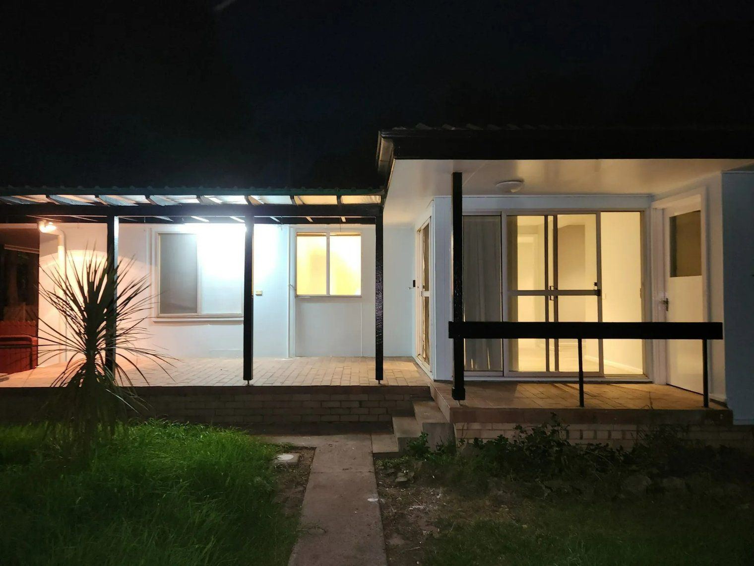 A house is lit up at night with a covered porch — Nicho's Home Maintenance In Armidale, NSW
