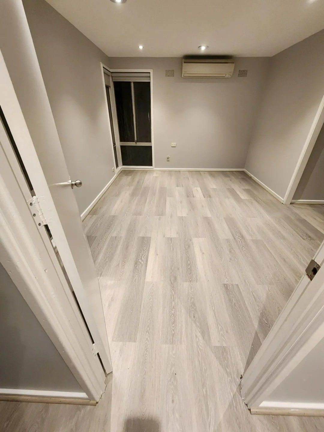 An Empty Room with A Wooden Floor and A Window — Nicho's Home Maintenance In Tamworth, NSW