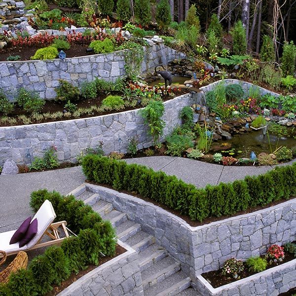A lush green garden with a stone wall and stairs A lush green garden with a stone wall and stairs