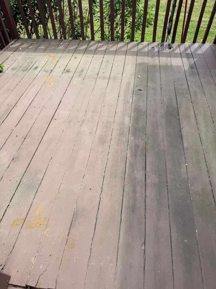 A wooden deck with a clean, light-colored section on the left and a darker, weathered section on the right.
