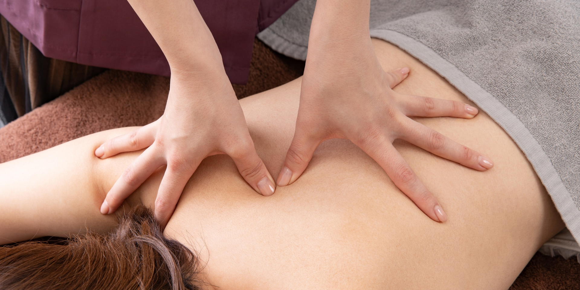 Hands giving a back massage.