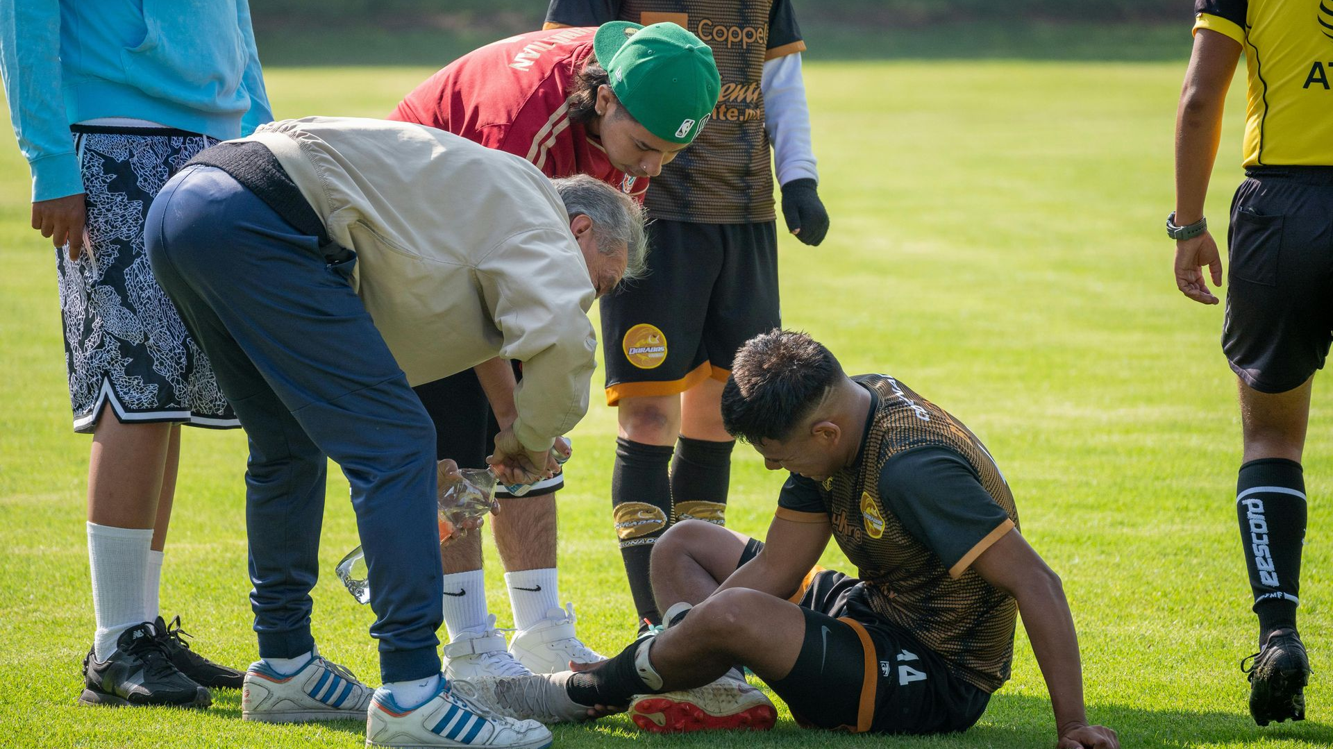 Soccer player injured on field; medical staff tending to him.