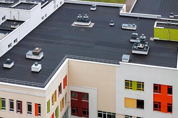 An aerial view of a large building with a black roof. An aerial view of a large building with a black roof.