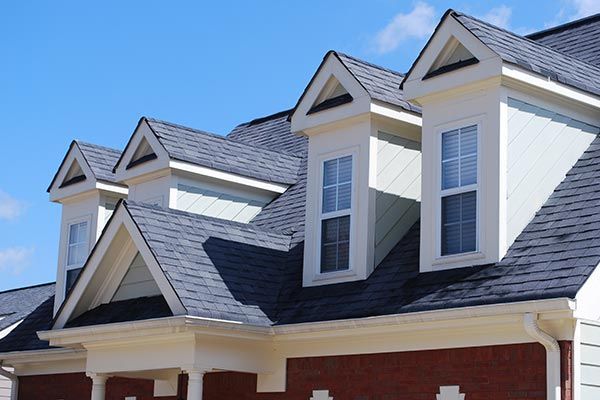 The roof of a house with a lot of windows and a blue sky in the background. The roof of a house with a lot of windows and a blue sky in the background.