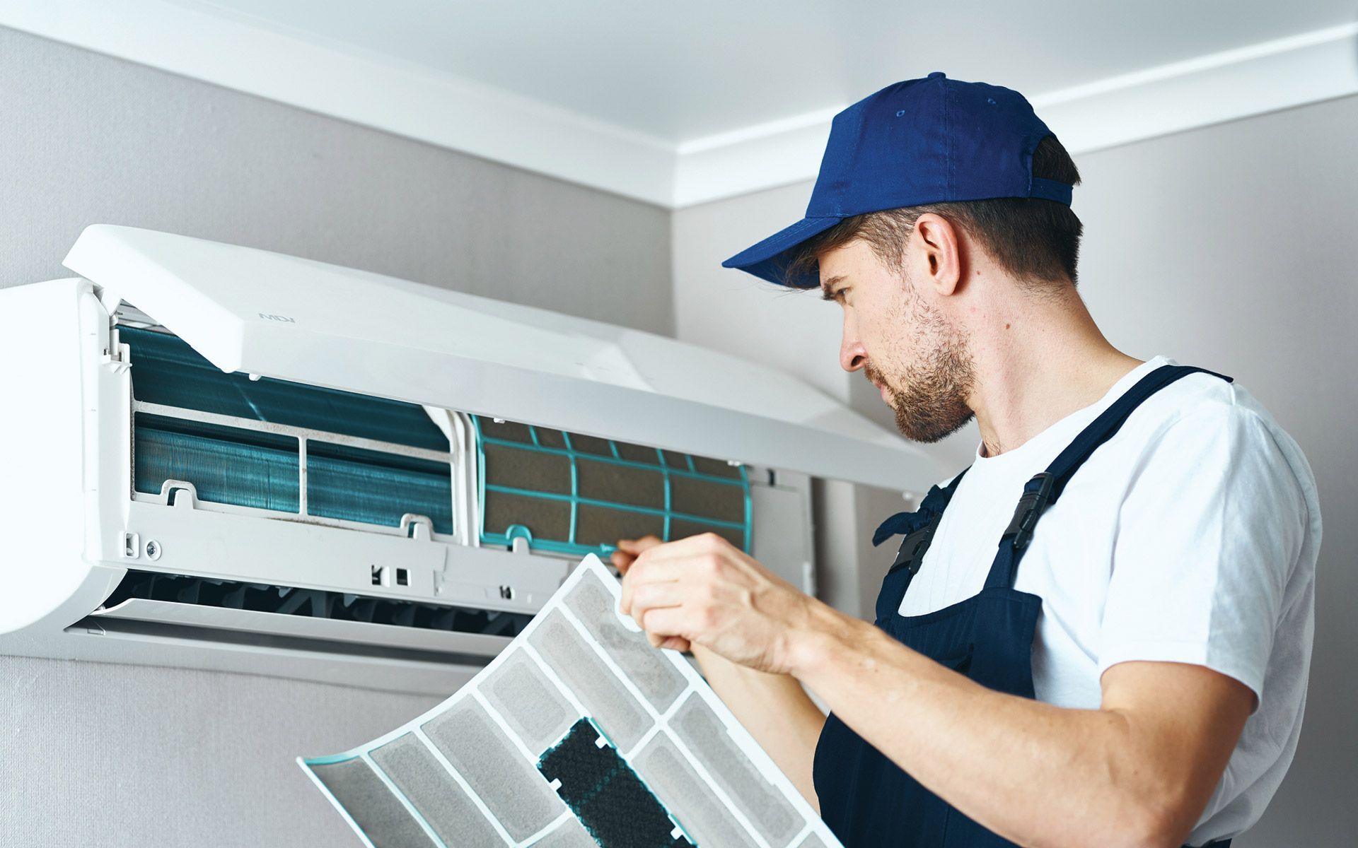 Man Fixing Air Conditioner — Manitowoc, WI — Schaus Mechanical Man Fixing Air Conditioner — Manitowoc, WI — Schaus Mechanical