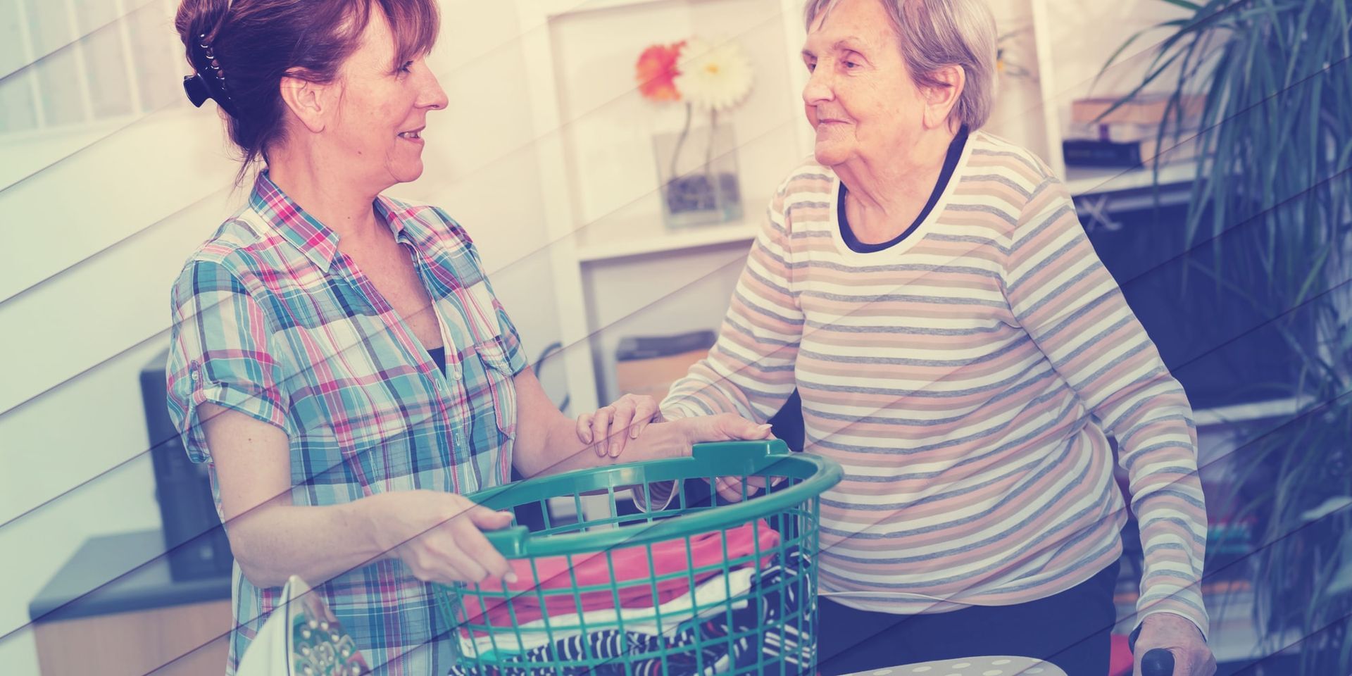 A woman is helping an elderly woman with a shopping basket.