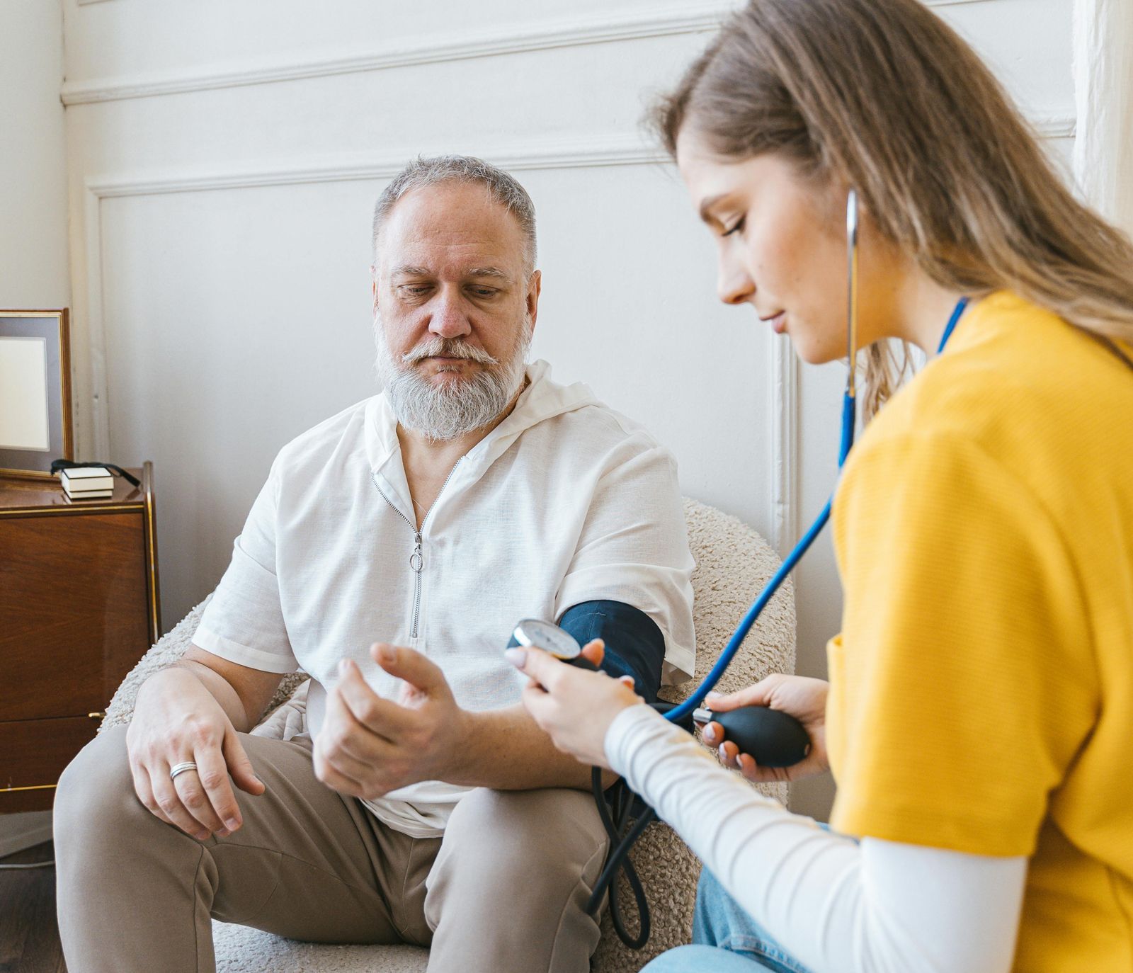Home nurse checking the blood pressure of a senior man