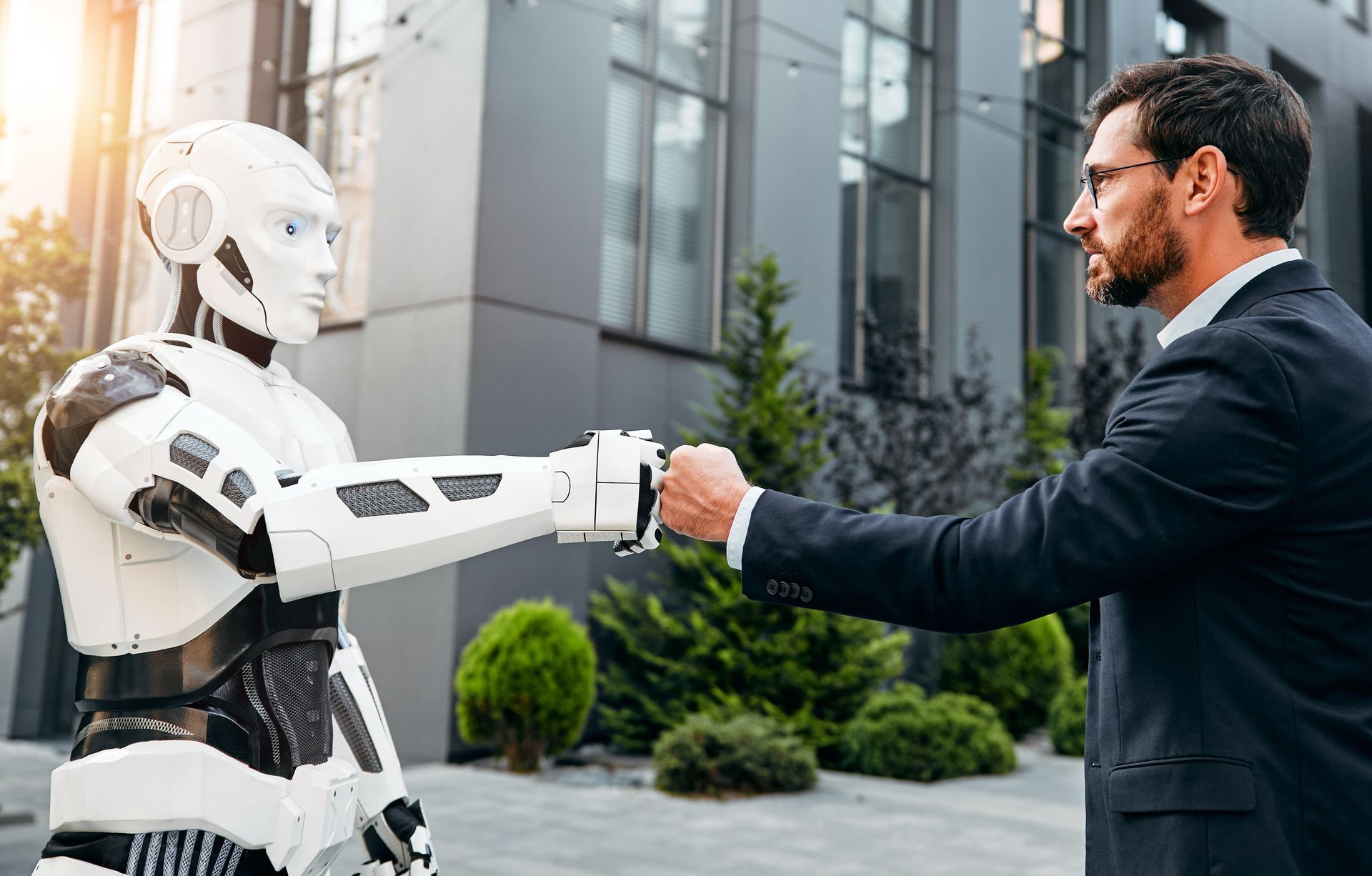 Een man in pak schudt de hand van een robot.