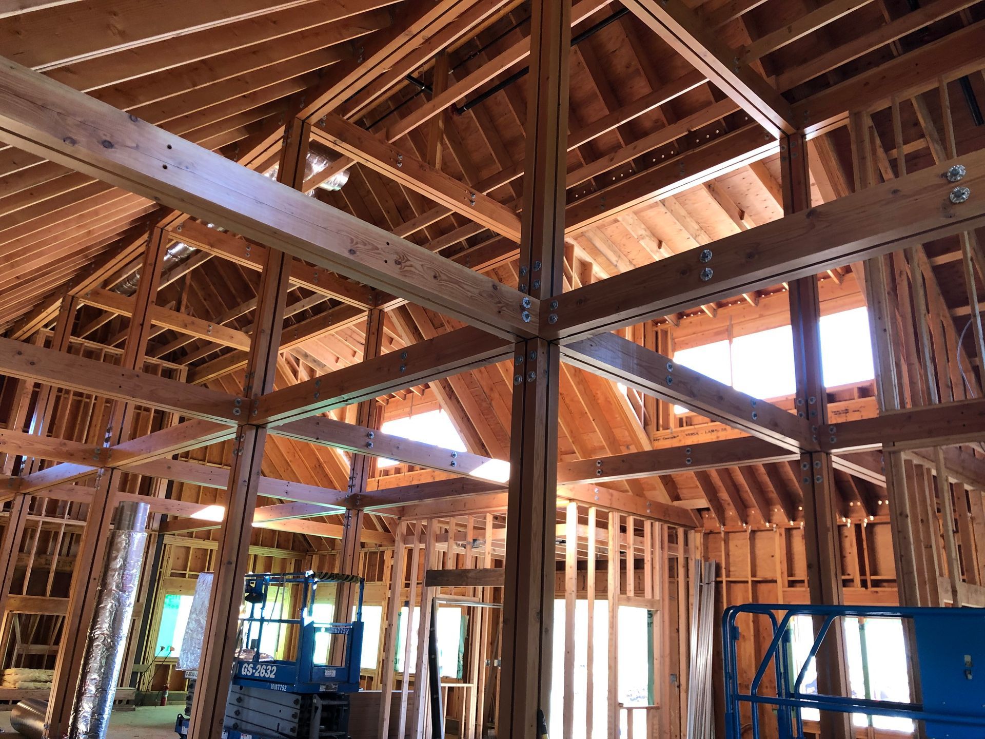 Interior view of a building under construction, with exposed wooden beams and framing.