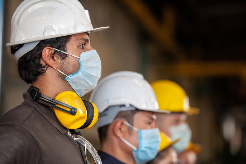 Lavoratori con caschi e dispositivi di protezione