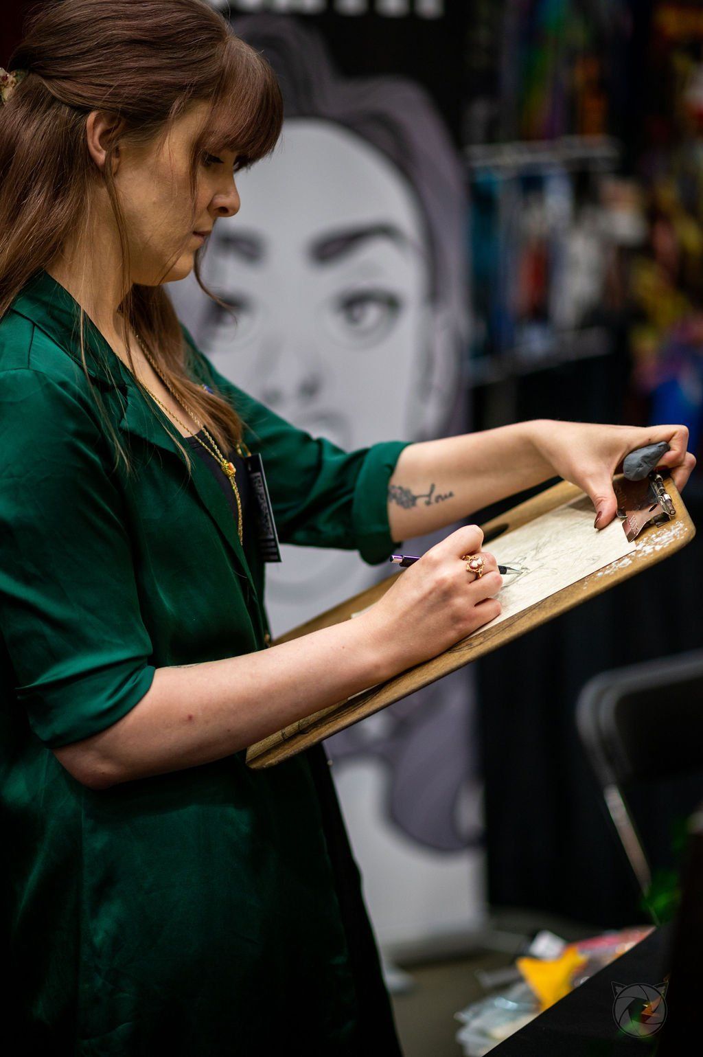 Artist showing his work off to exhibitors walking past at the 2022 Capital City Comic Con event