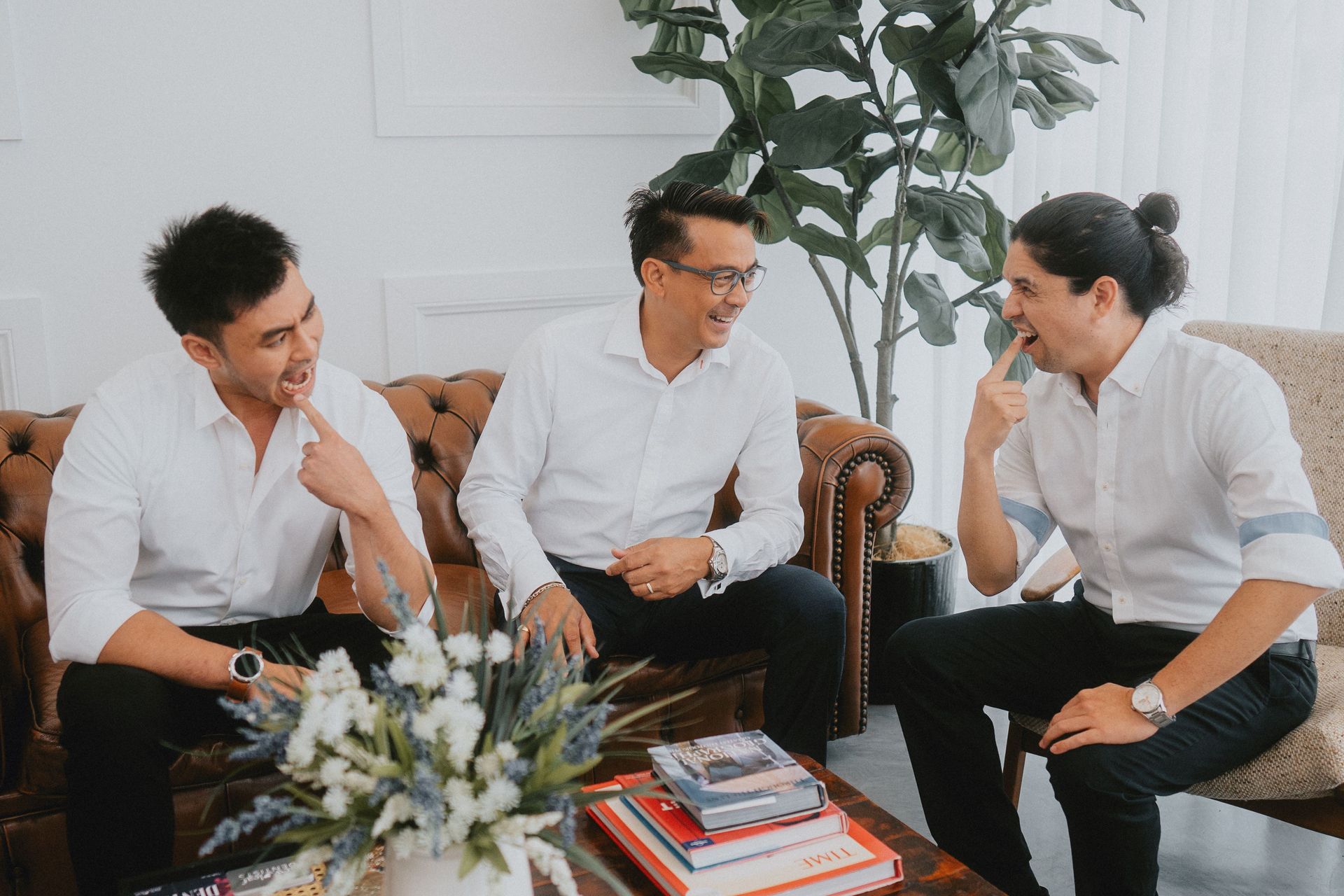 Three Men Seated, Laughing, in a Bright Room — New Leaf Dentists In Erina, NSW