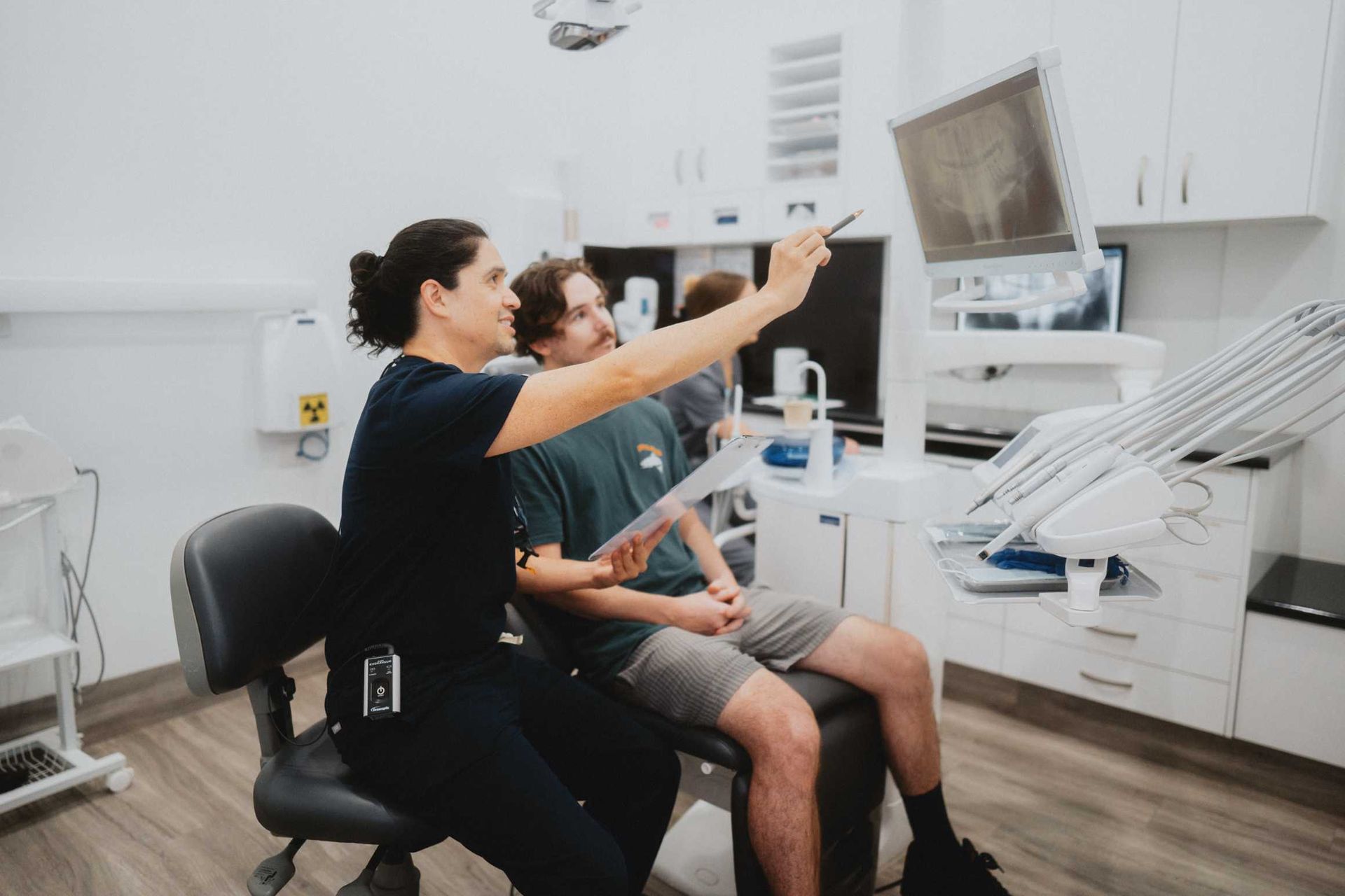Dentist Showing a Patient a Dental X-ray on a Monitor in a Bright Dental Office — New Leaf Dentists in Erina, NSW