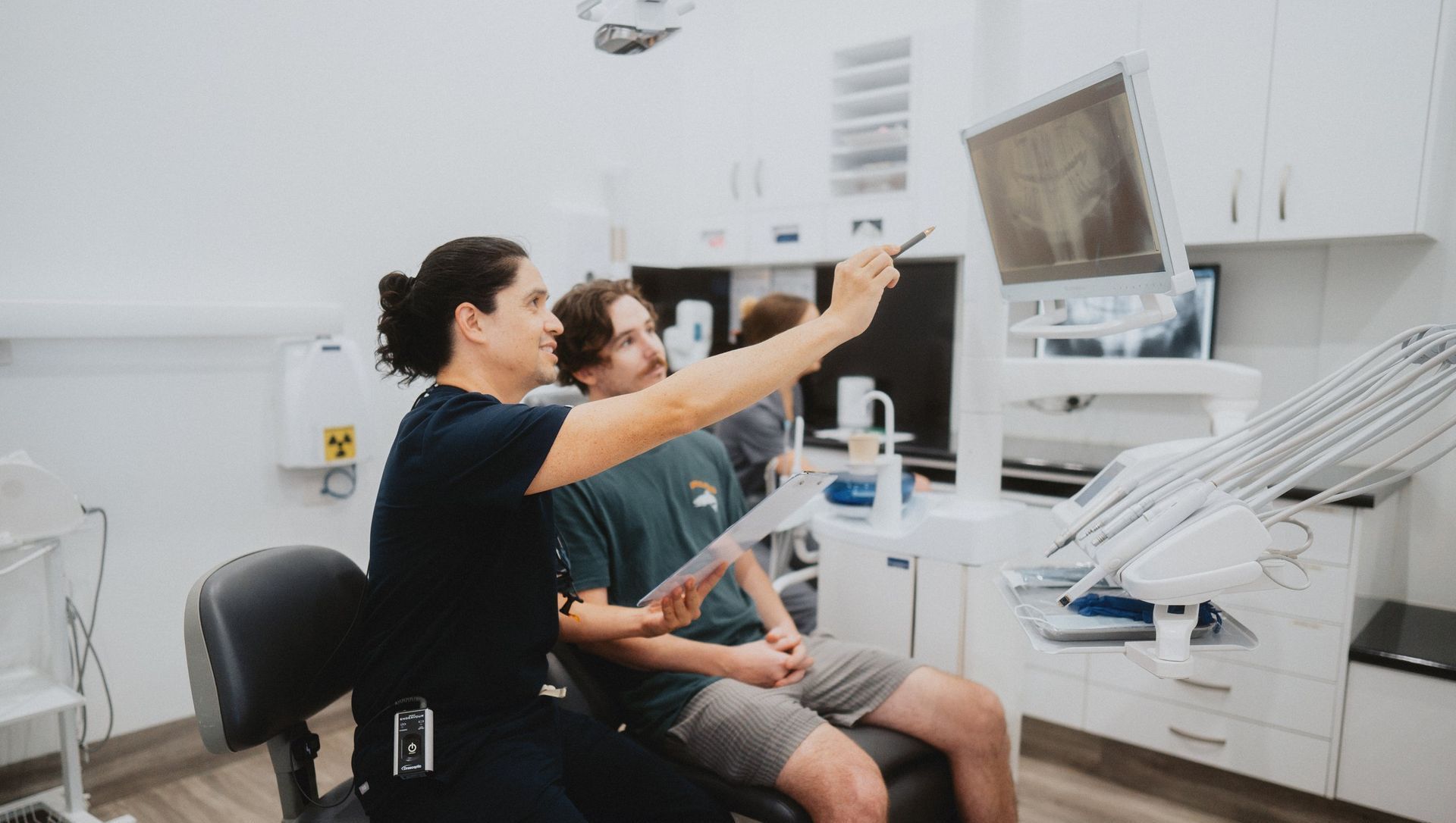 A Dentist is Talking to a Patient in a Dental Chair — New Leaf Dentists in Erina, NSW