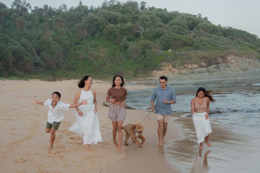 Family Running on a Beach With a Dog — New Leaf Dentists In Erina, NSW