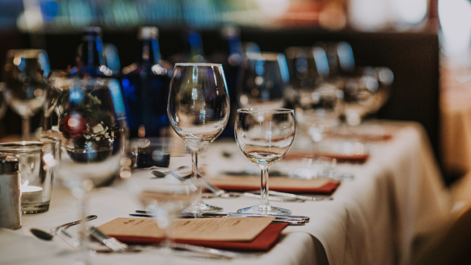A row of wine glasses on a table in a restaurant.