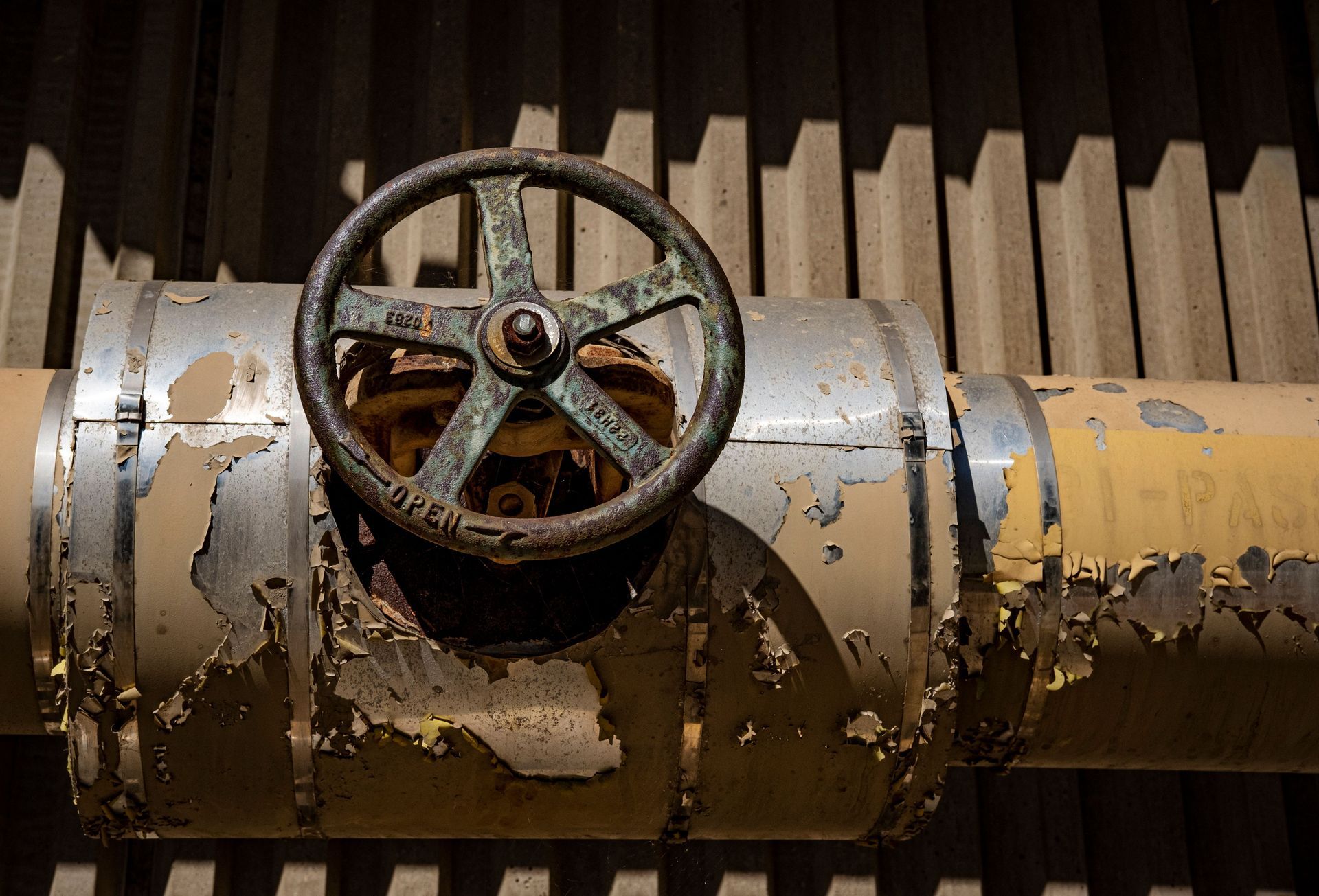 Rusty valve and weathered metal pipe showing heavy corrosion