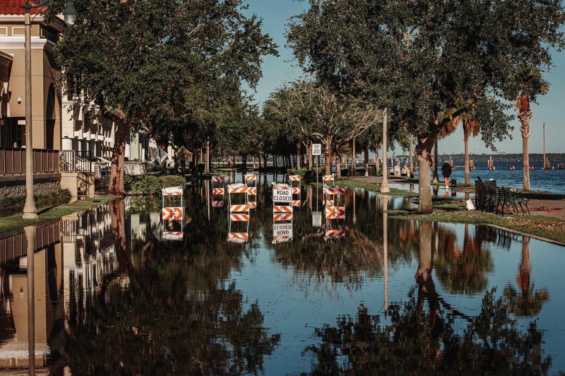 Flooded street in South Florida with road-closed signs after a storm