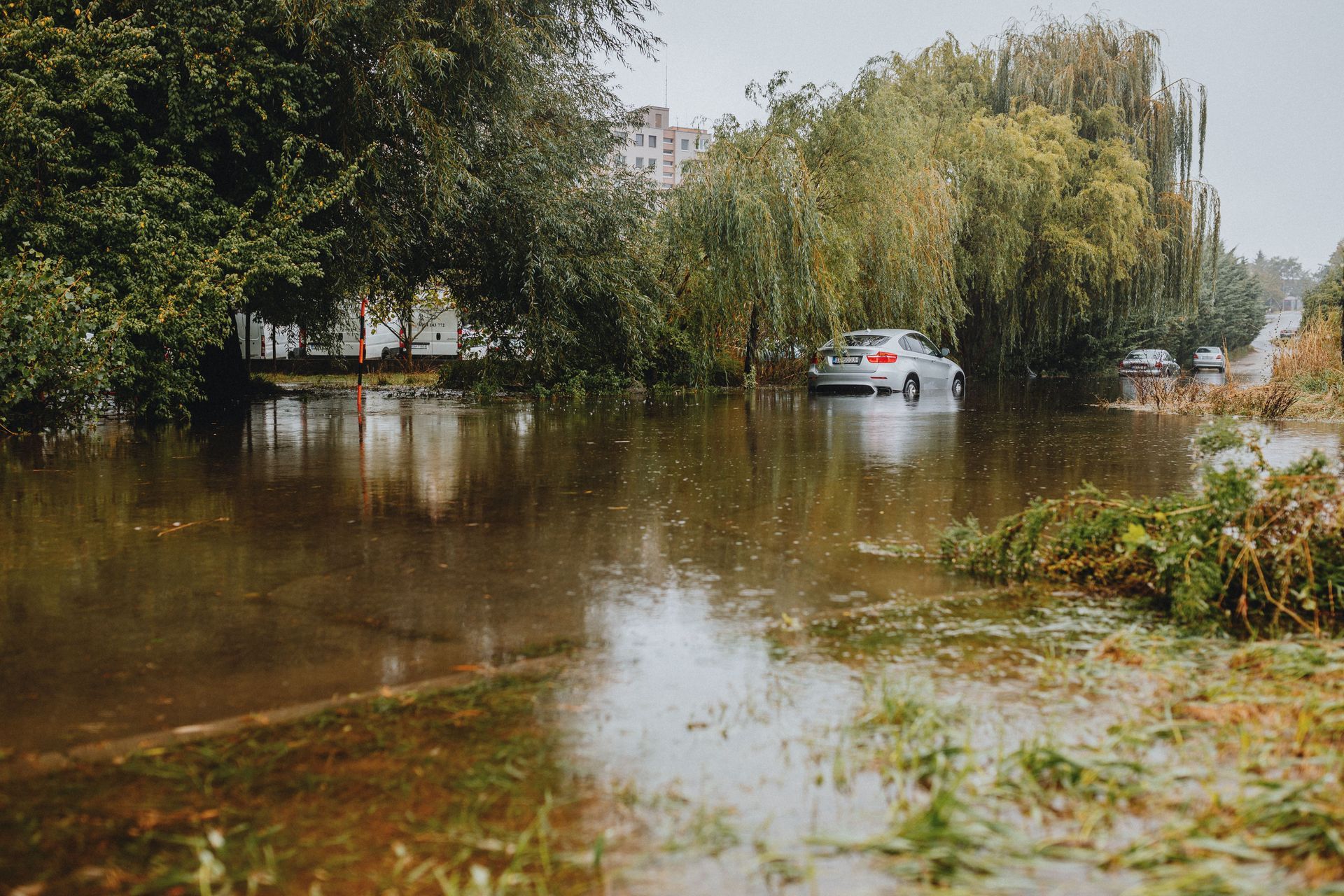 Car driving through a flooded residential street after a heavy storm