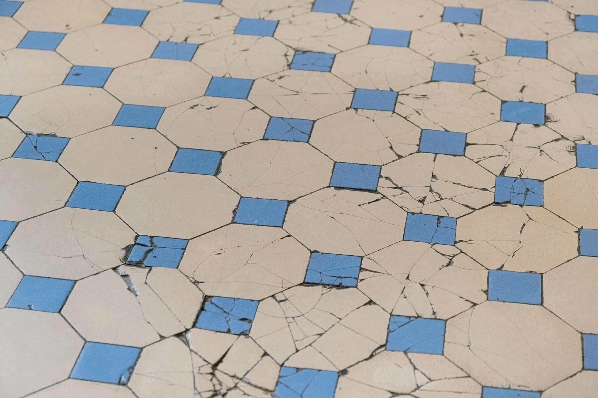 Aged floor tiles with visible cracks in an older home