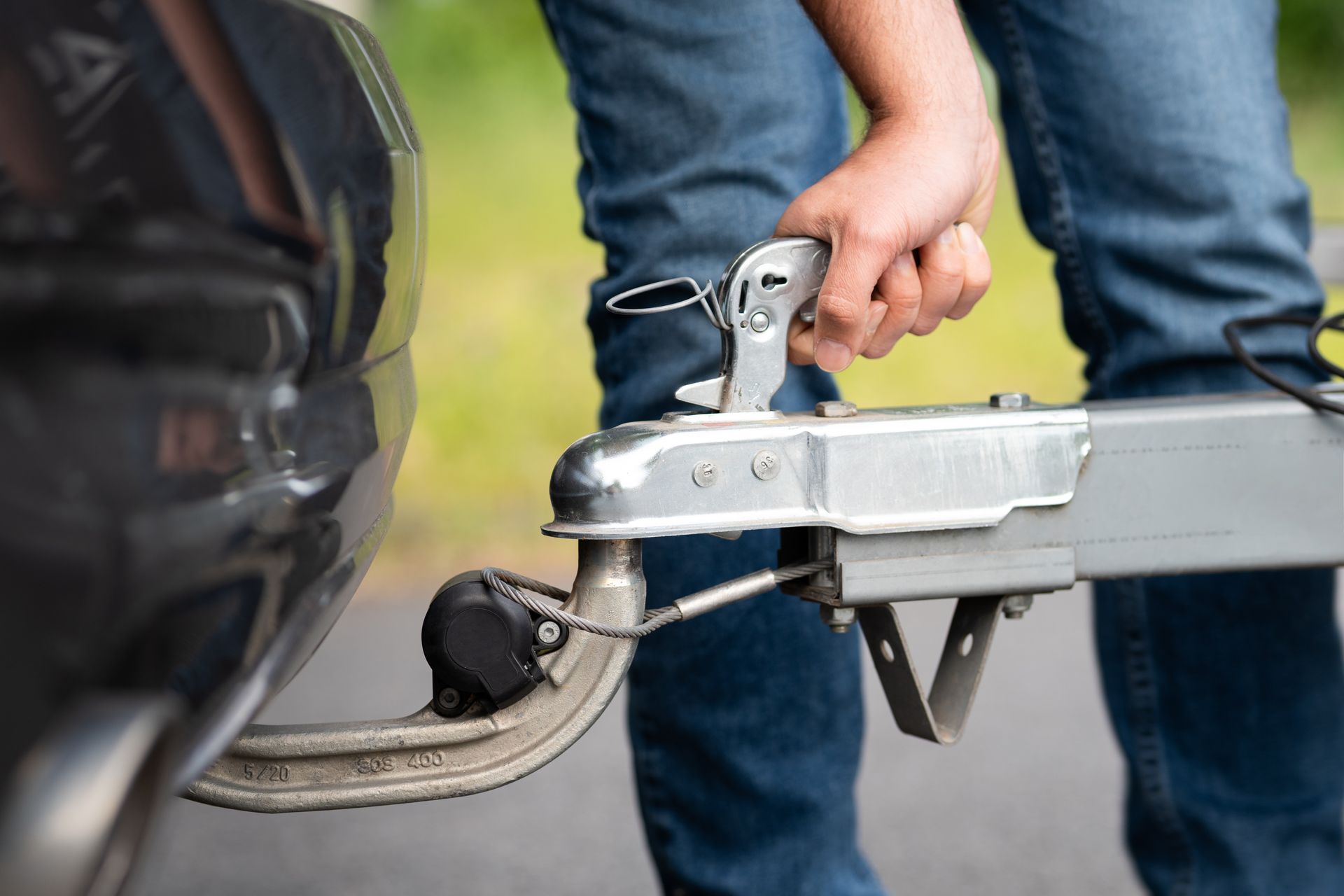 Trailer coupler locking onto a hitch ball below a vehicle's rear bumper