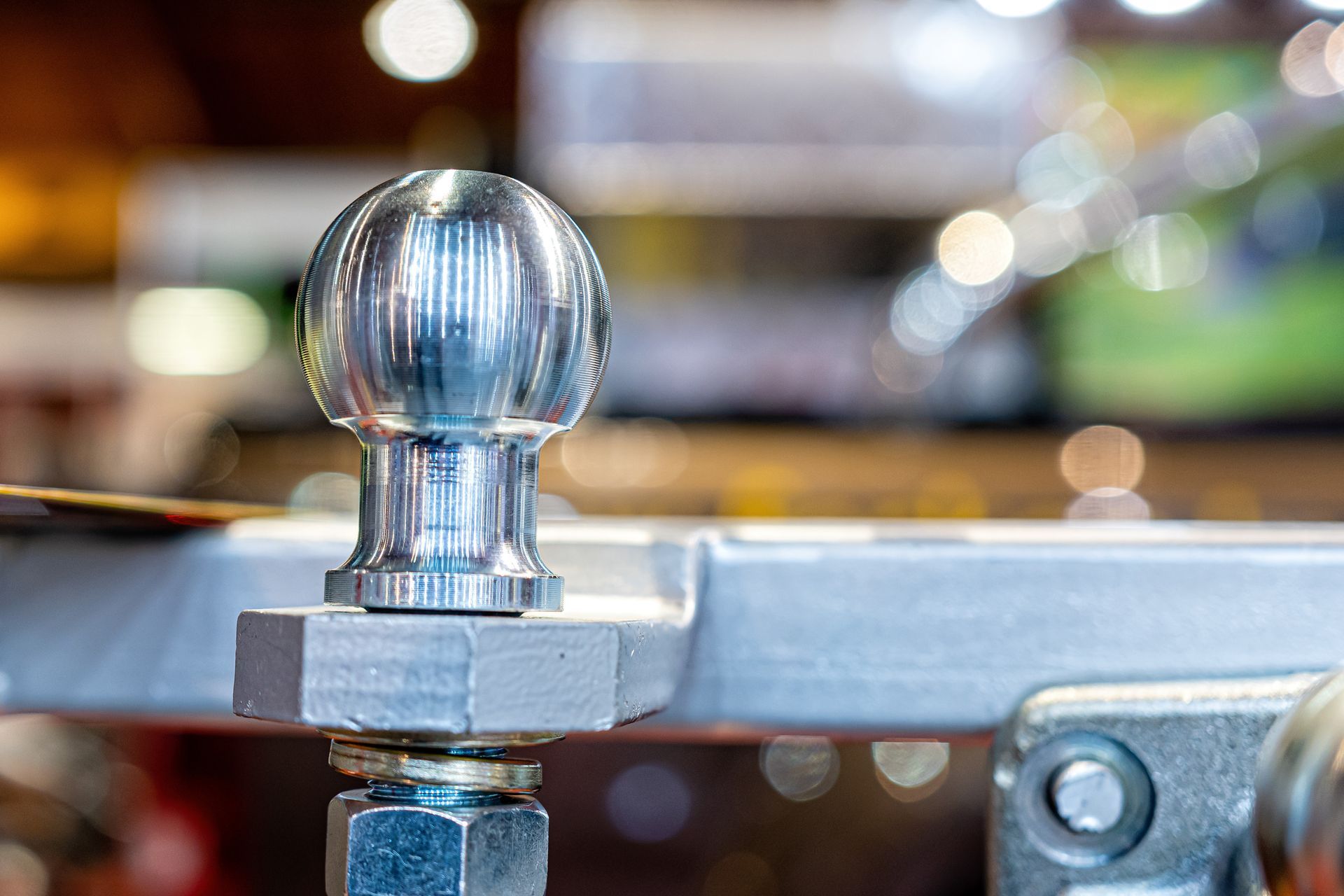Close-up of a polished chrome trailer hitch ball from a truck accessories store.] 