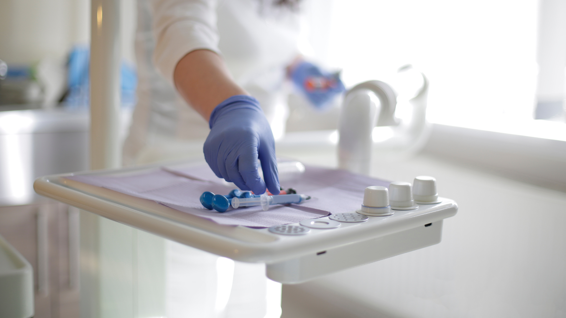 A dentist is cleaning a dental chair in a dental office.