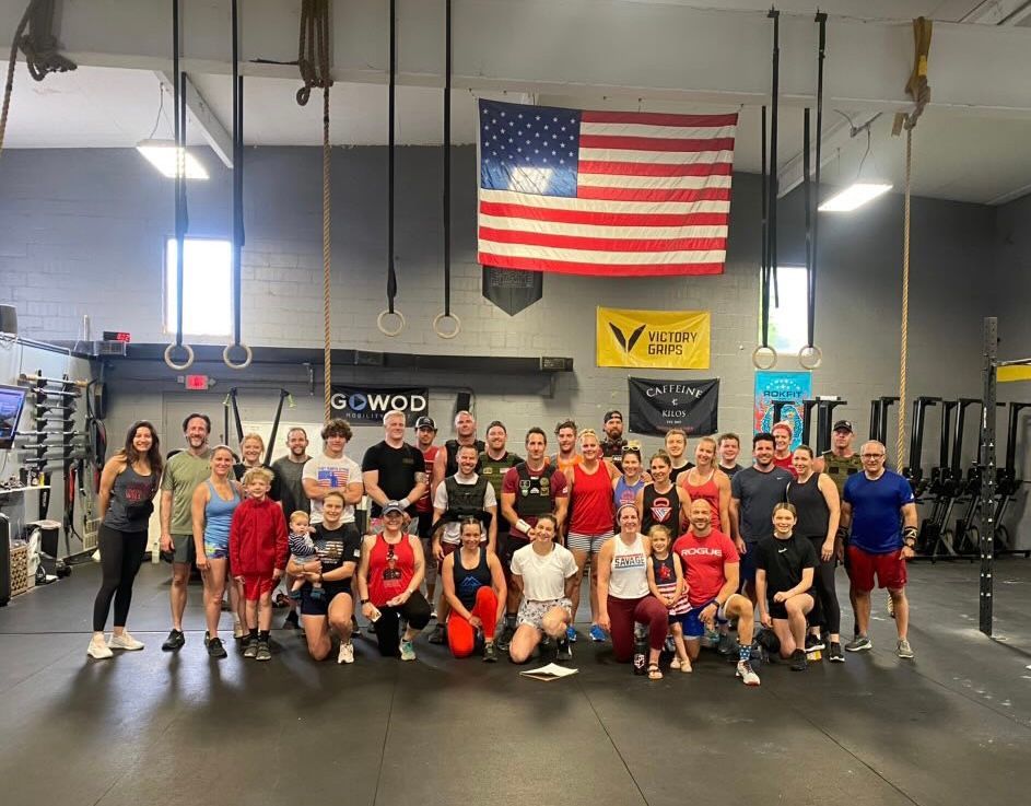 A group of people are posing for a picture in a gym.