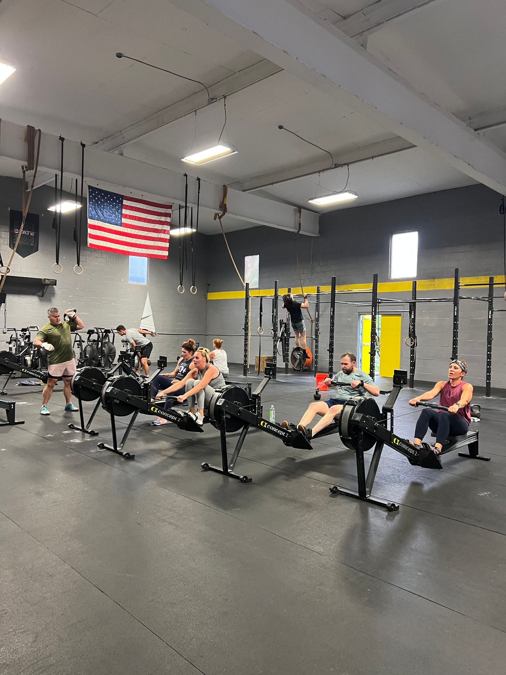 A group of people are rowing rowing machines in a gym.