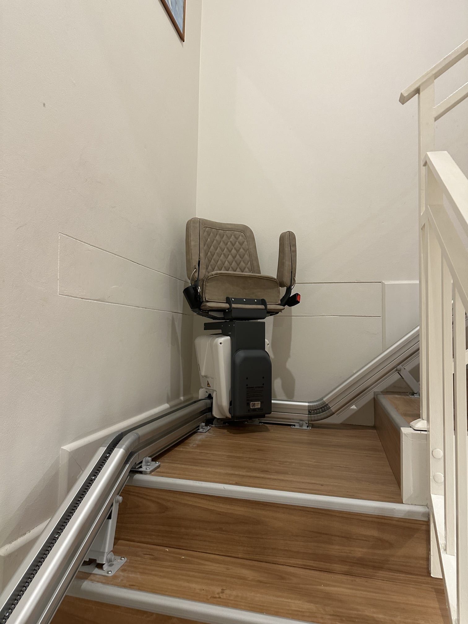 Indoor stairlift on a narrow wooden staircase in a home