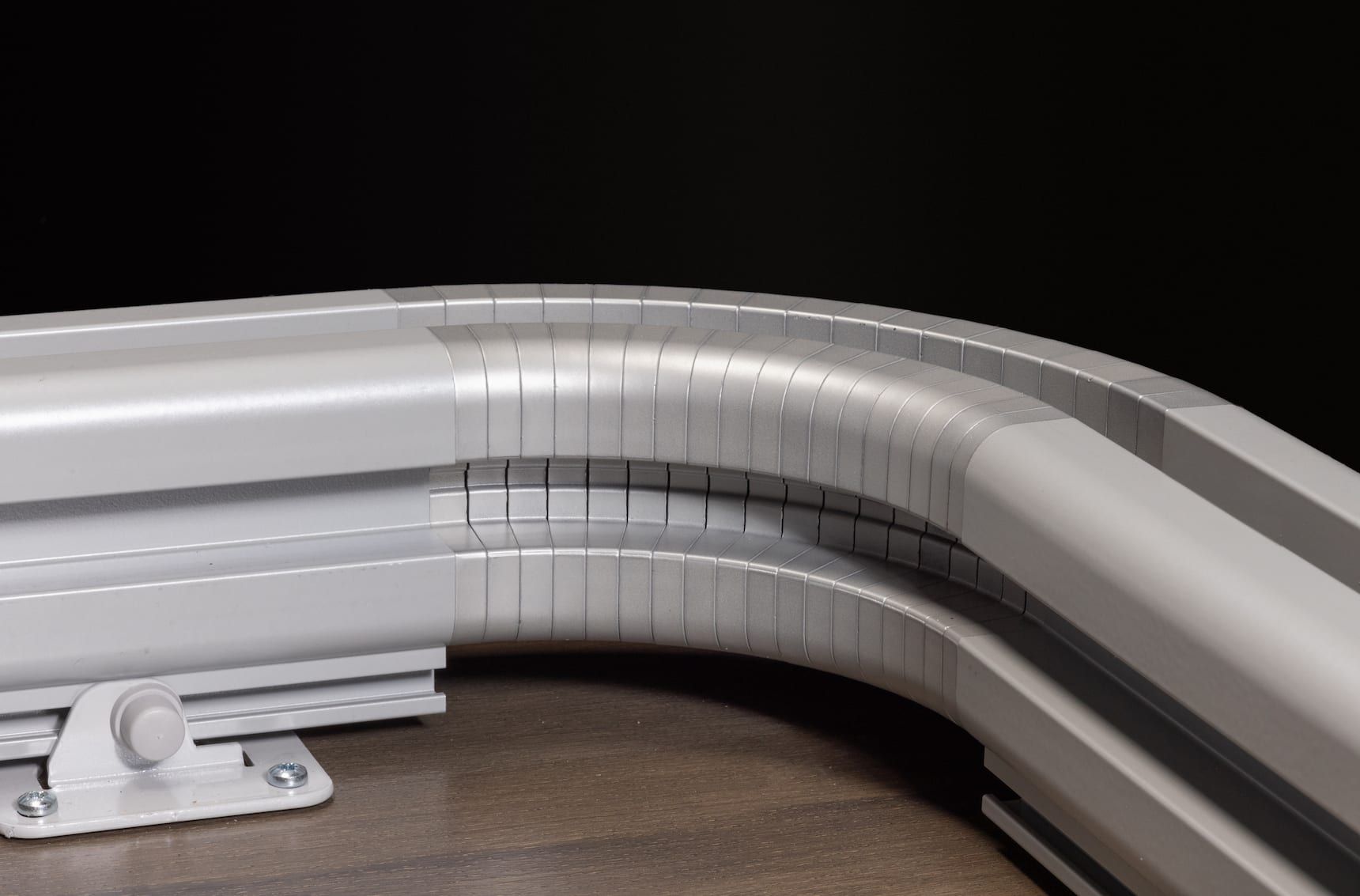 Curved white metal guardrail with a visible crack or joint damage at the bend