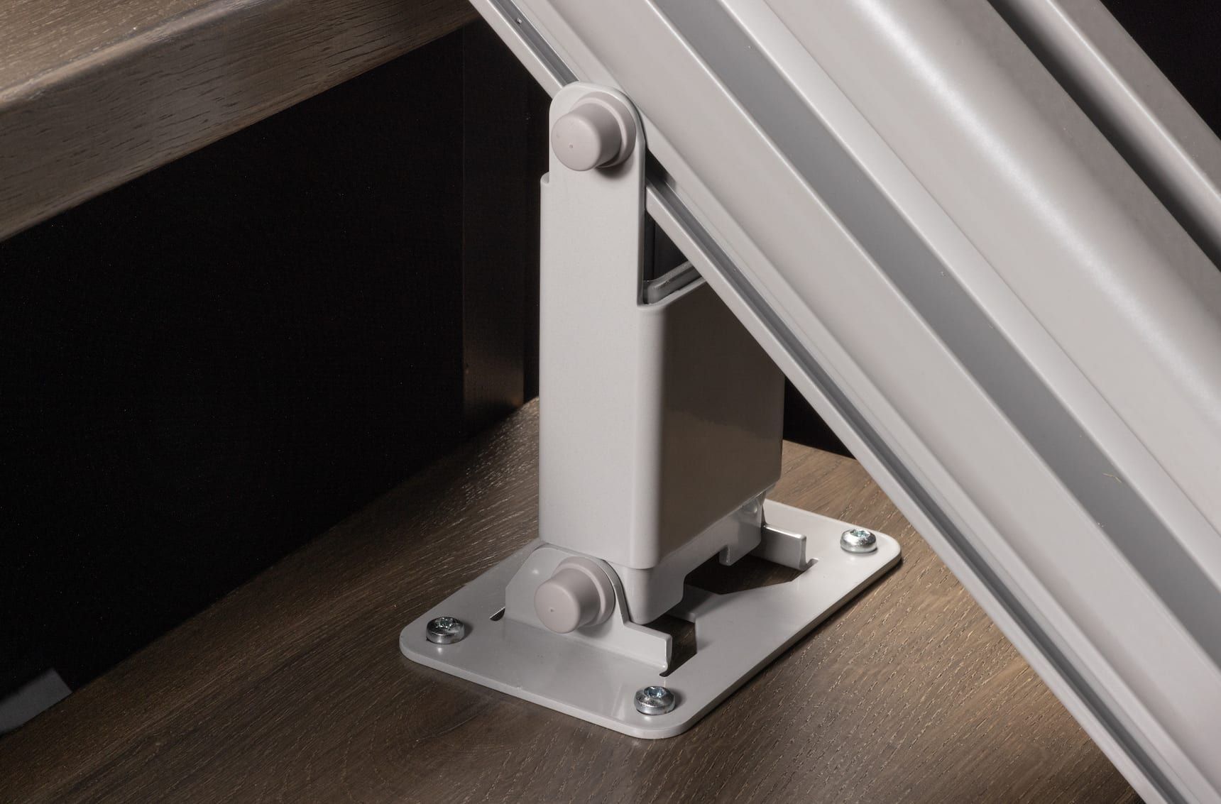 Close-up of a metal hinge bracket securing a slanted panel to a floor plate.