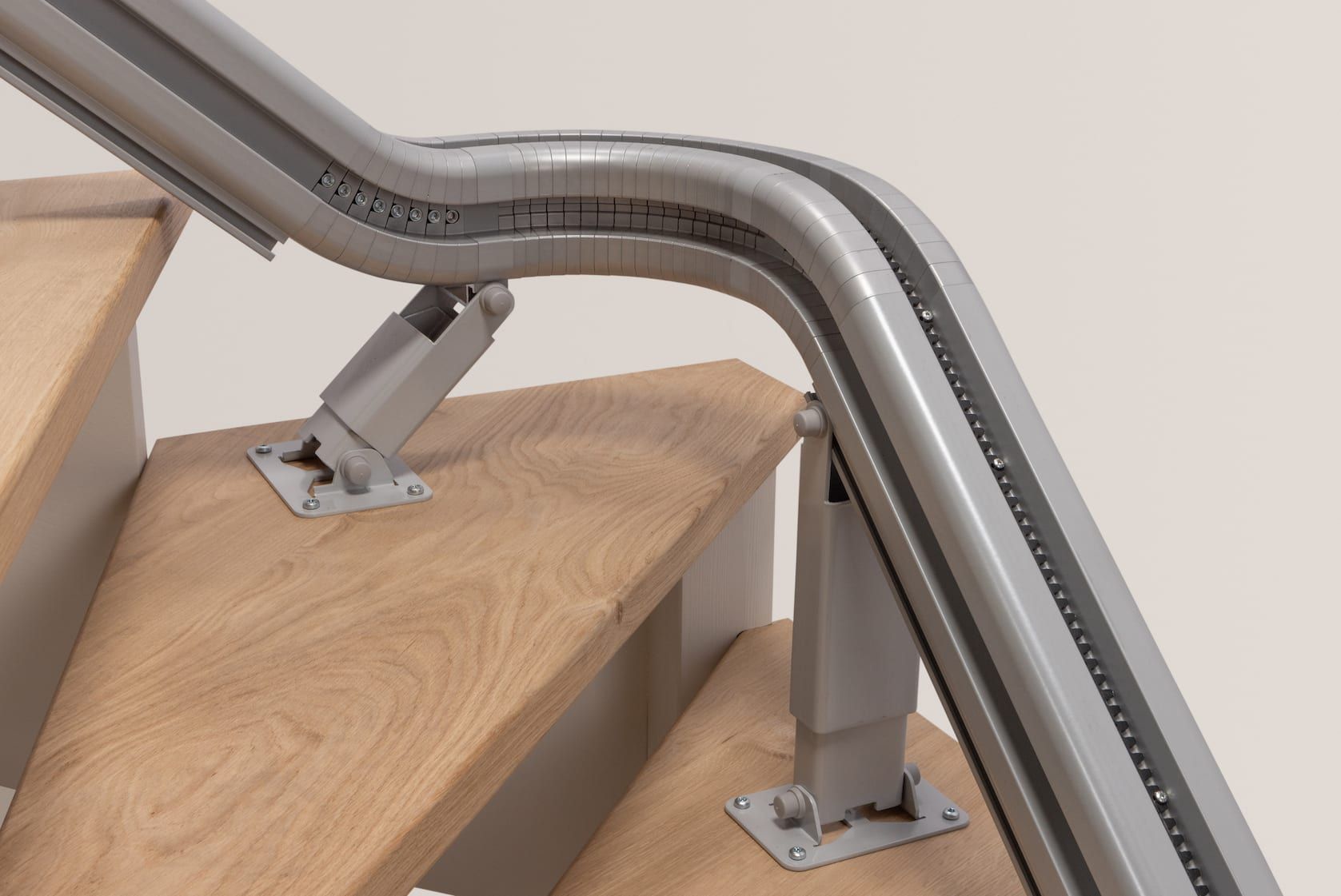 Metal stair handrail mounted on wooden steps with brushed steel supports