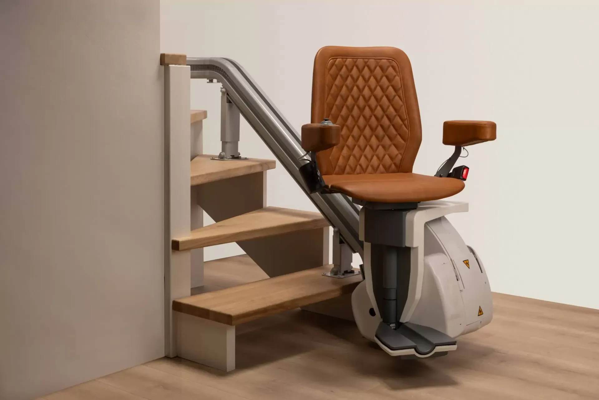 Woman on a stairlift smiles, ascending a wooden staircase beside a white wall.