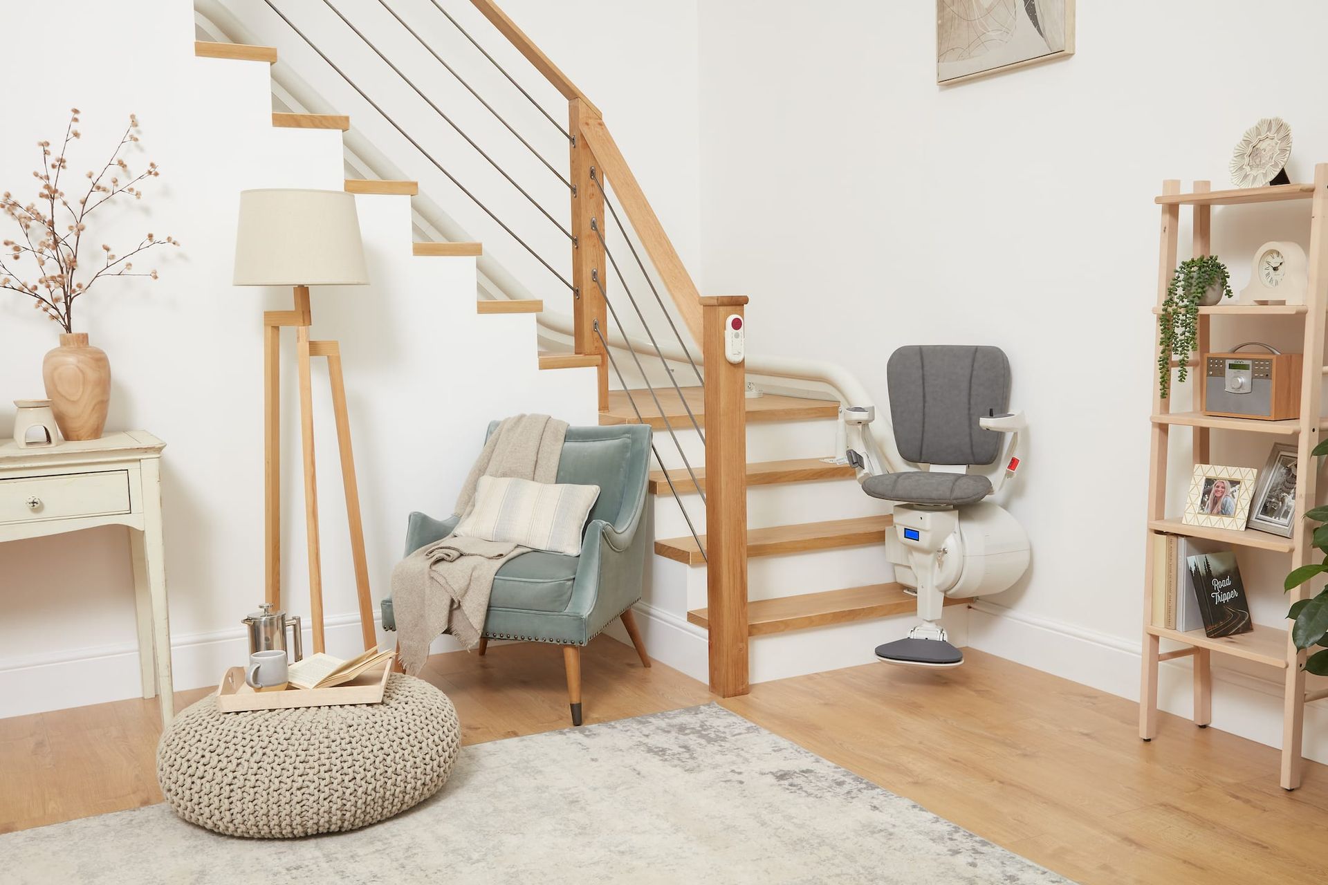 Stair lift installed on a wooden staircase in a home with neutral decor.
