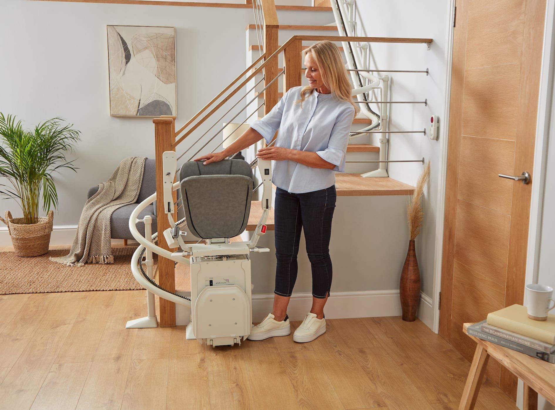 Woman adjusting a stair lift in a bright home interior