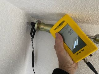 Eine Person hält ein gelbes Gerät, auf dessen Bildschirm 99 steht.