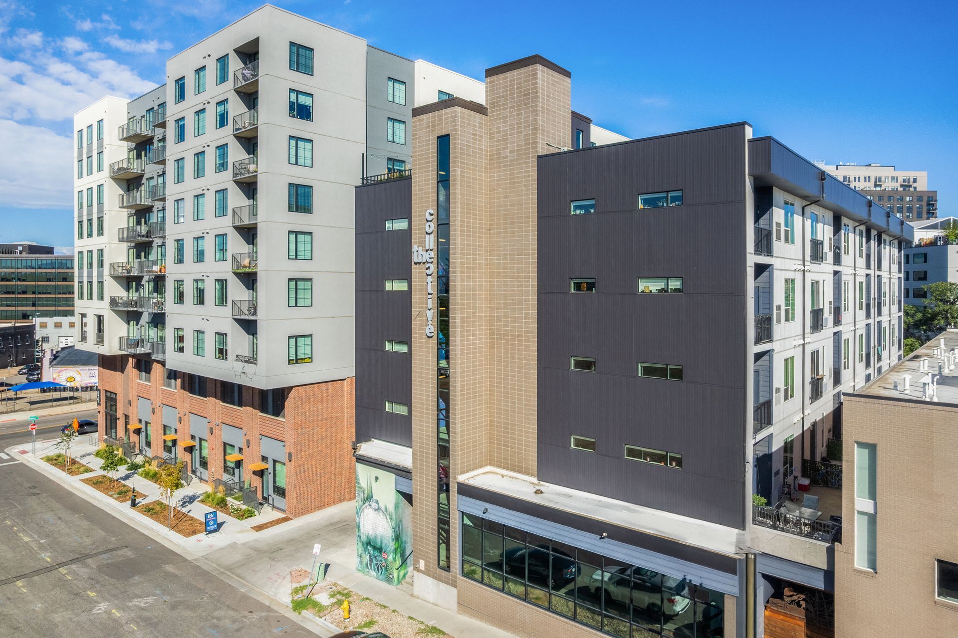 Multi-story modern apartment building with various facades against a blue sky.