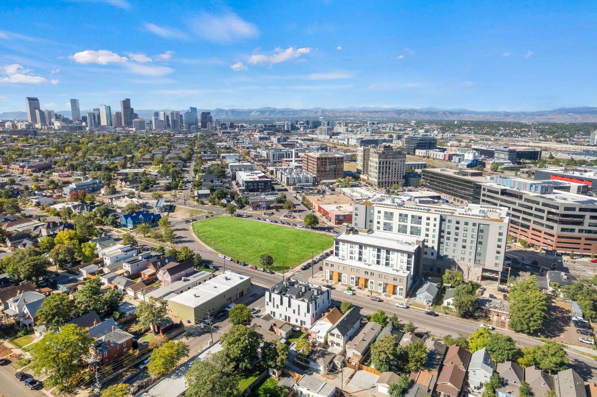 Cityscape view of Denver with residential and commercial buildings under a blue sky.