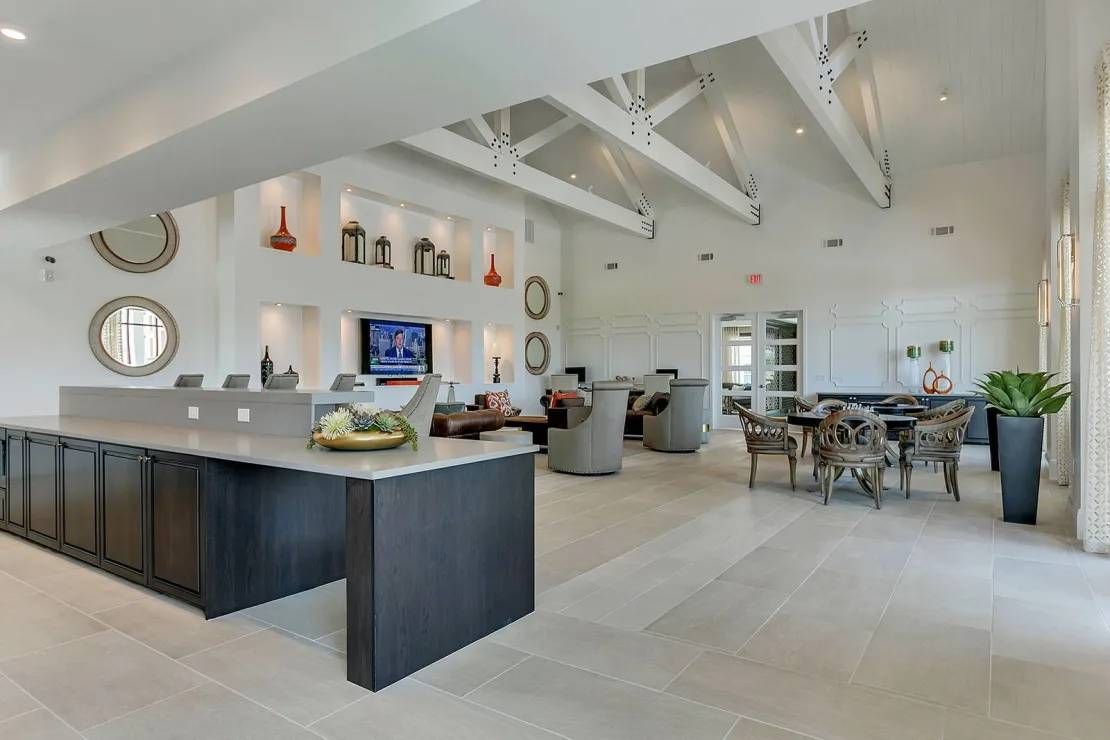 Modern open-concept kitchen and dining area with white beams, dark island, and large windows