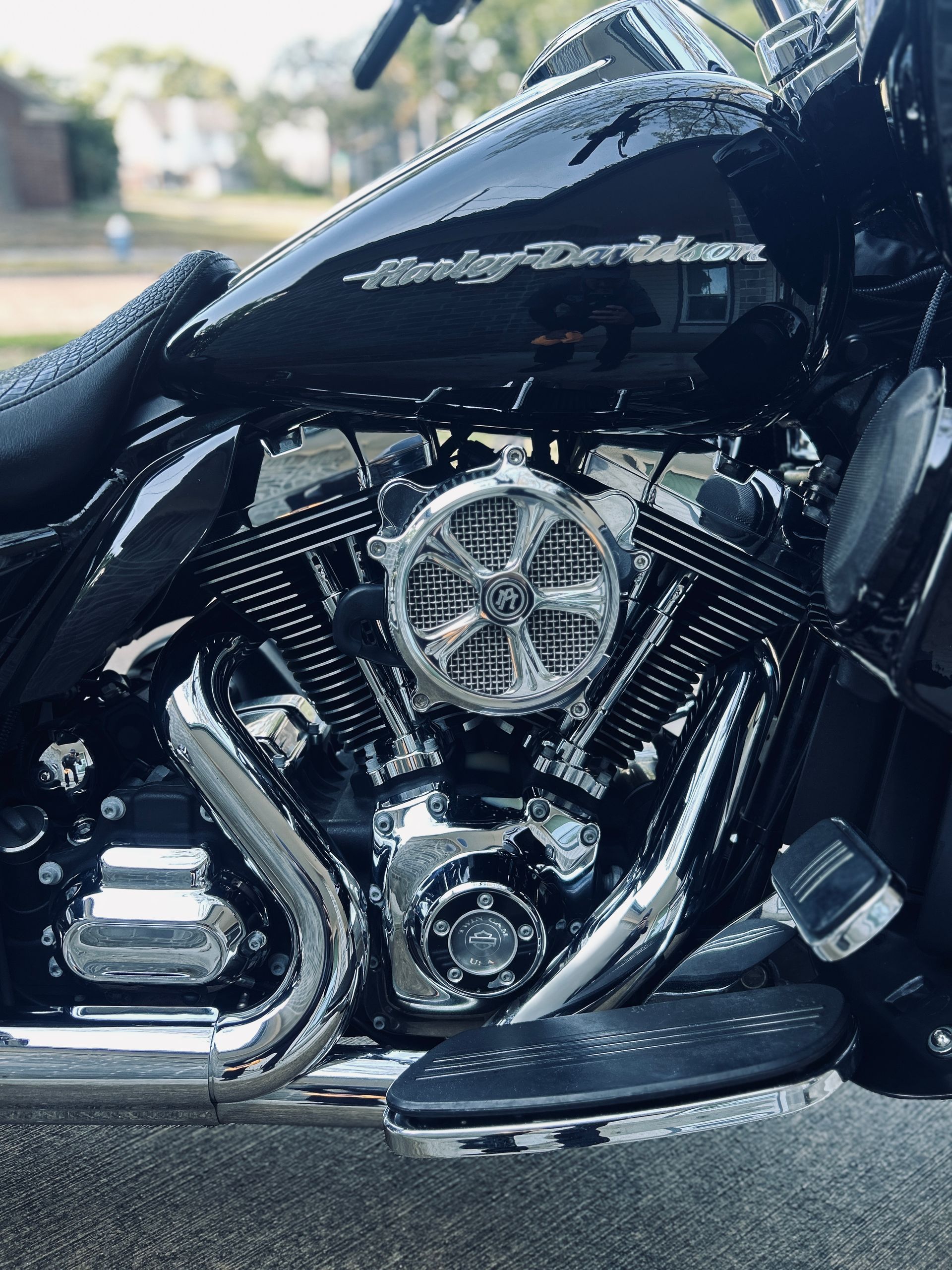 Black Harley-Davidson motorcycle with chrome accents, parked outdoors, engine visible.