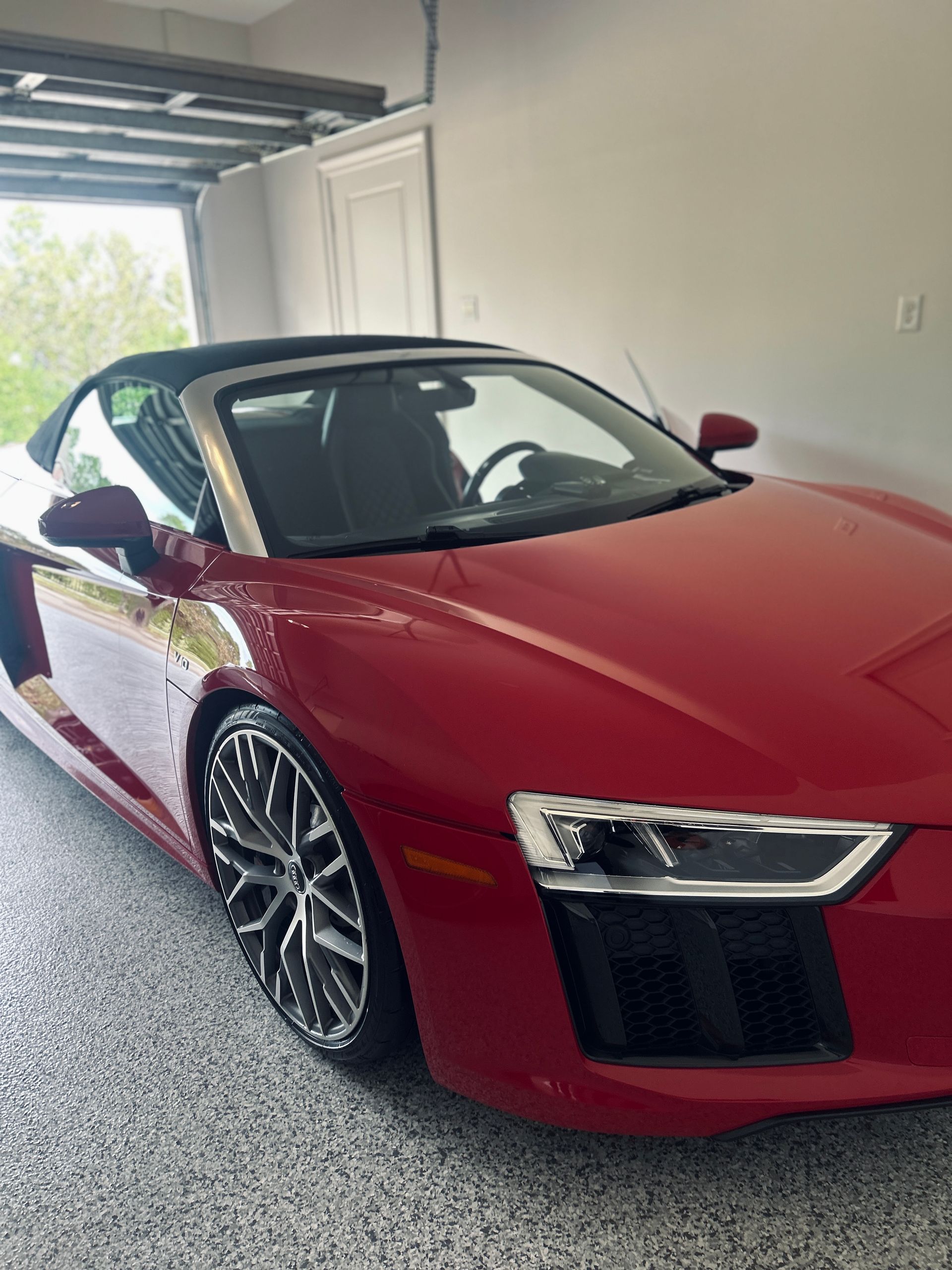 Red Audi R8 convertible parked inside a garage.