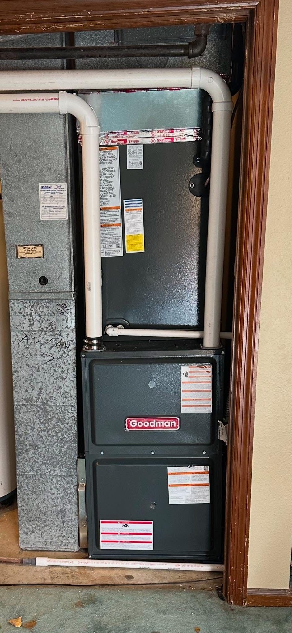 An air conditioner is sitting in a closet next to a door.