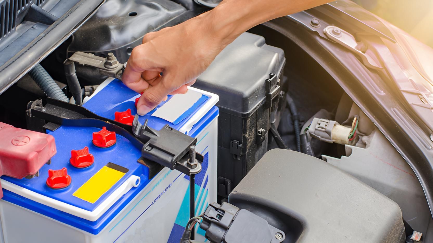 A Person is Plugging a Battery Into a Car — Cessnock Batteries In Kurri Kurri, NSW