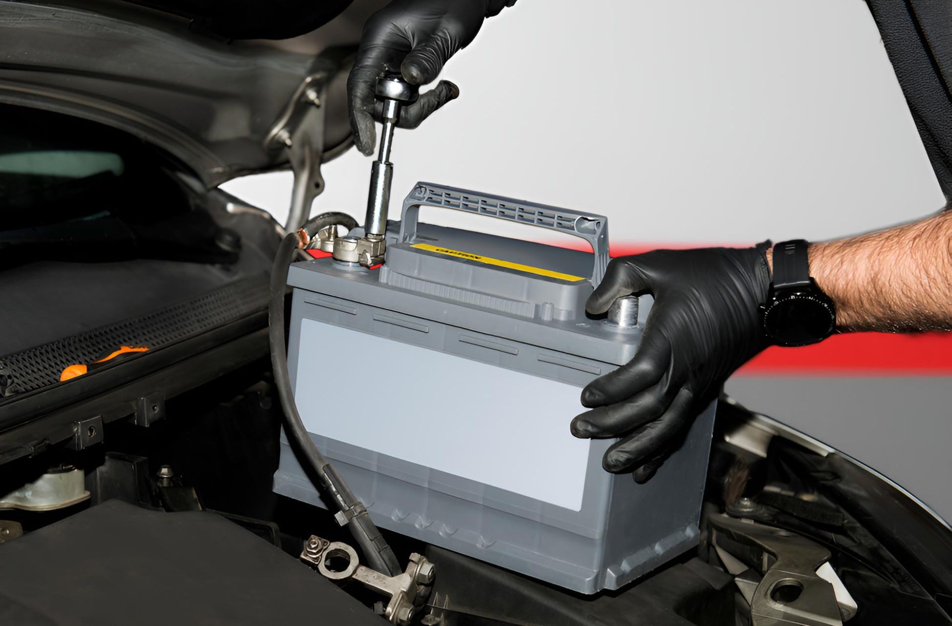 A Person is Holding a Battery in Their Hands Under the Hood of a Car — Cessnock Batteries In Bellbird, NSW