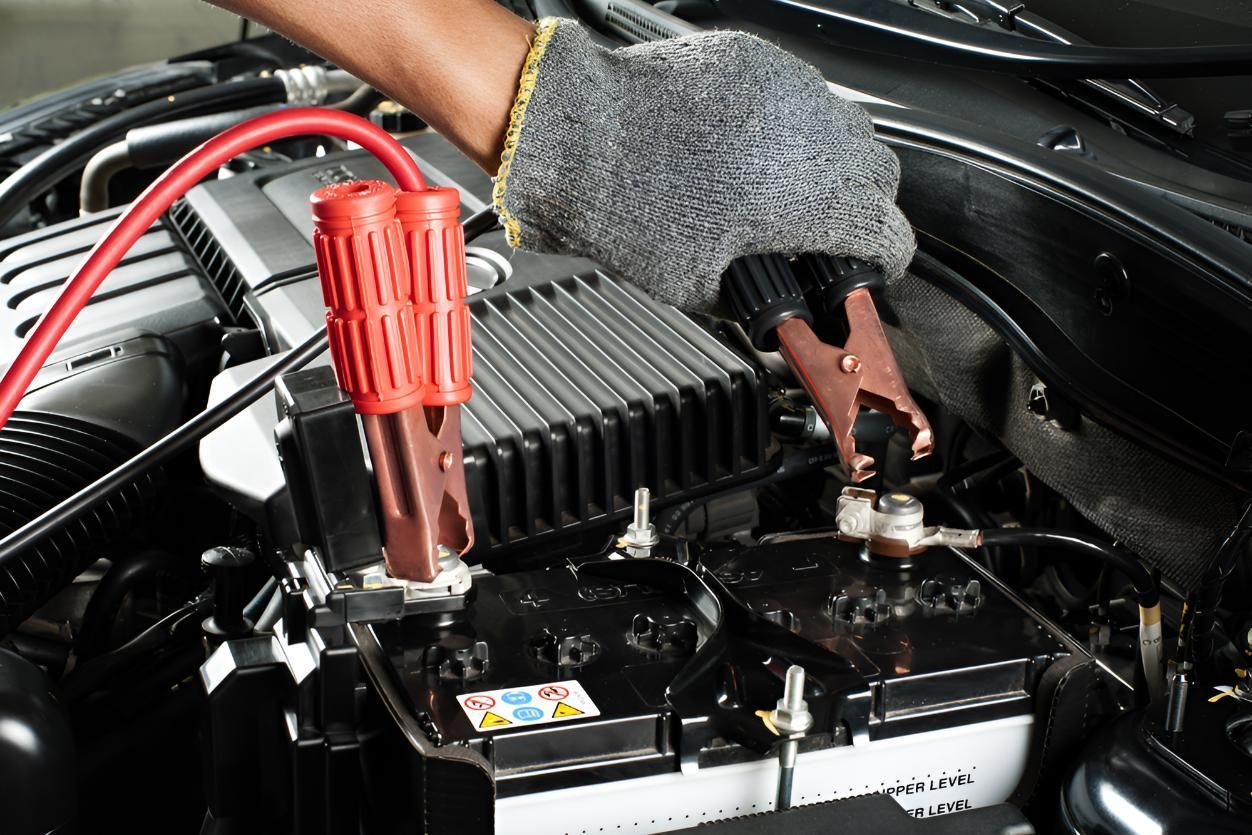 A Person is Charging a Car Battery With Jumper Cables — Cessnock Batteries In Maitland, NSW